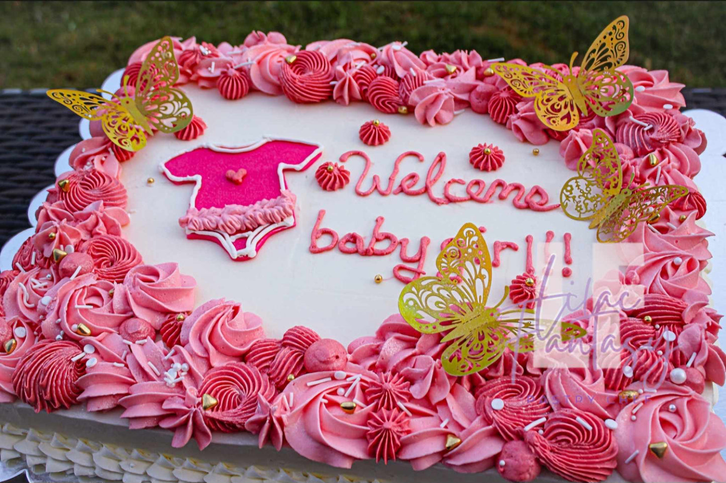 Pink 1/4 sheet cake stating welcome baby girl baked by pastry chef Lilac