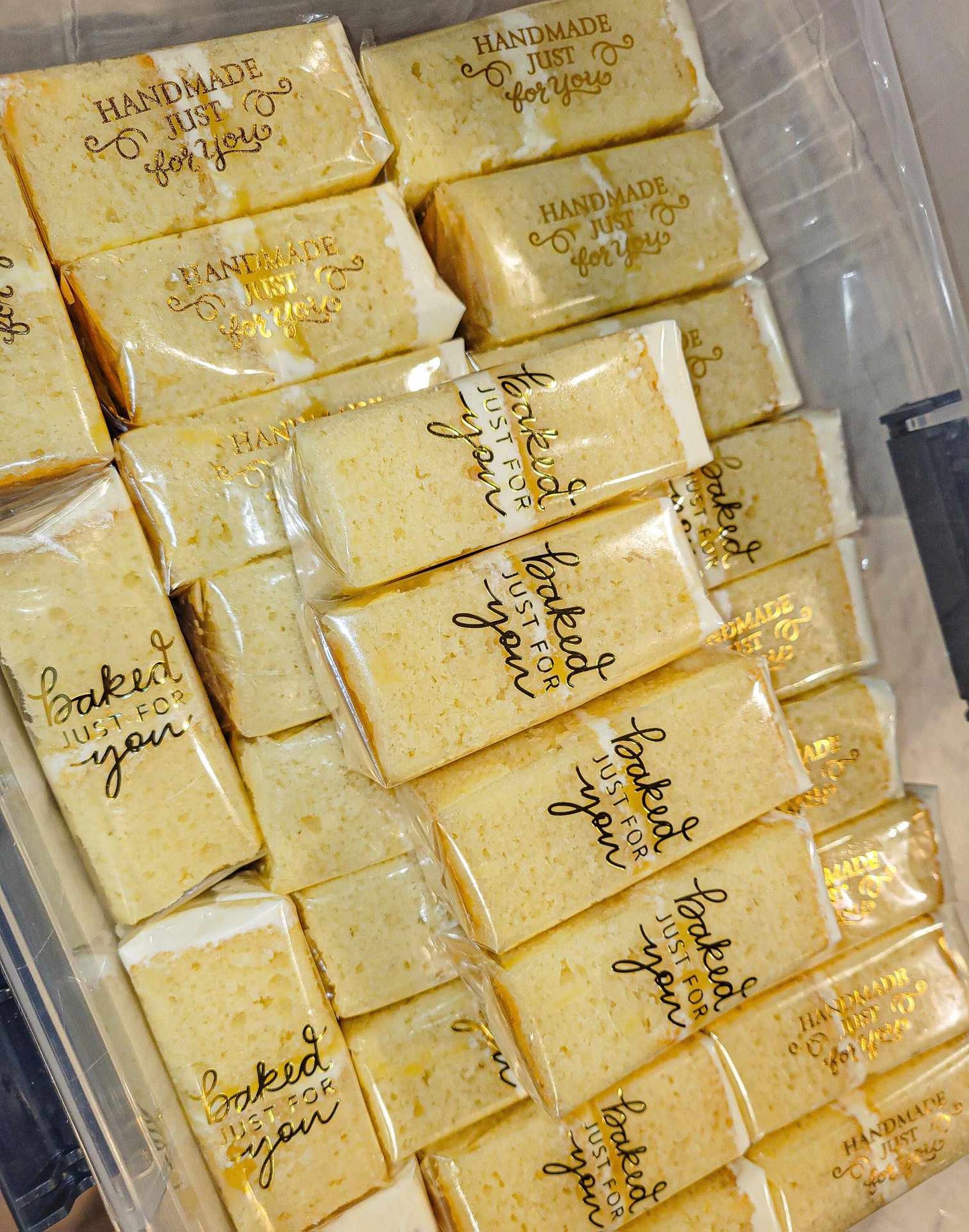 Multiple yellow cake slices individually wrapped in "baked just for you" by pastry chef Lilac