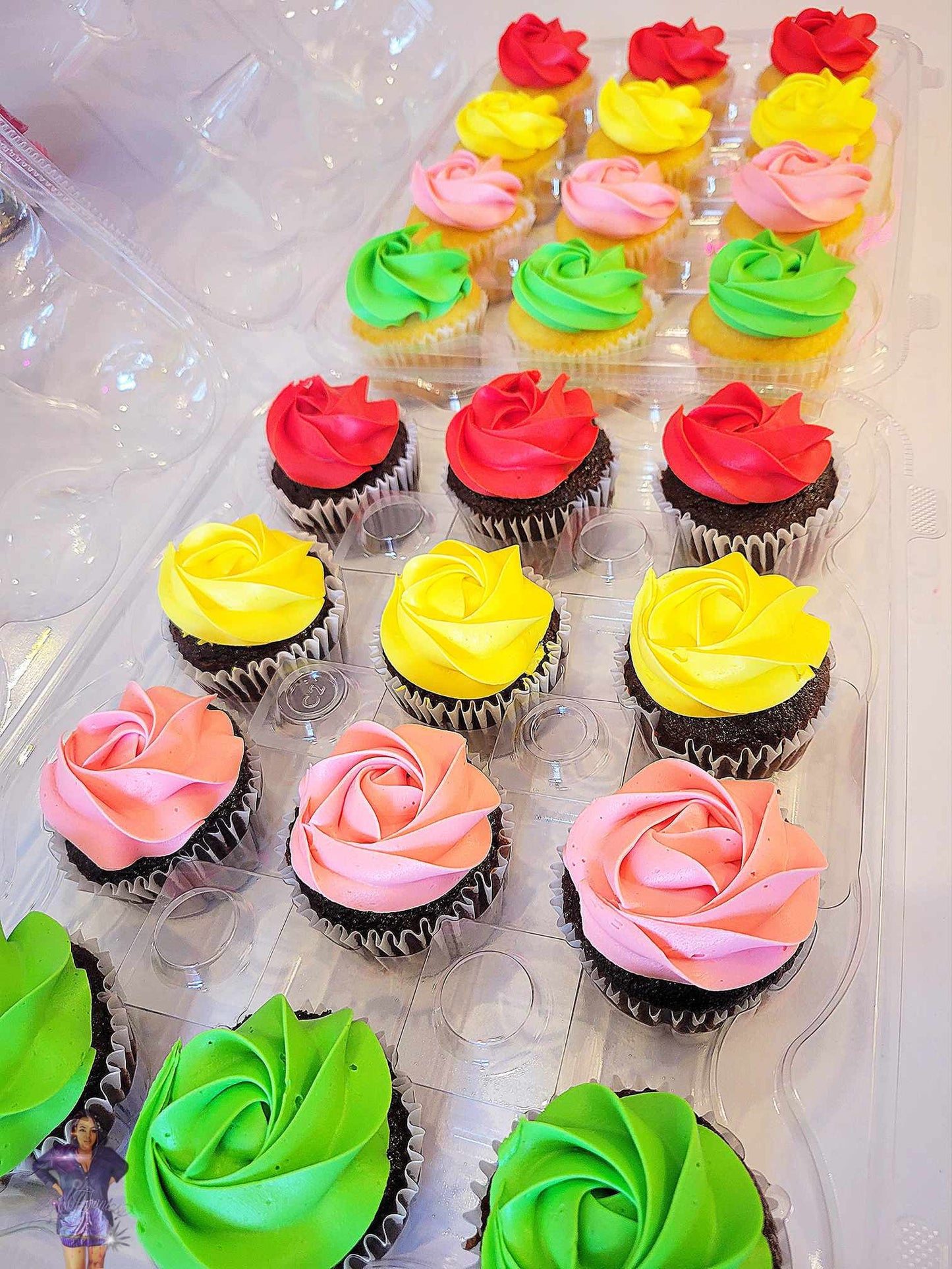 Multiple green, pink, yellow, red cupcakes that look like roses baked by pastry chef Lilac